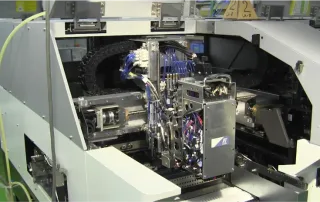 Bestückkopf eines SMD-Bestückungsautomaten nimmt Bauteile auf und platziert sie präzise auf die Leiterplatte